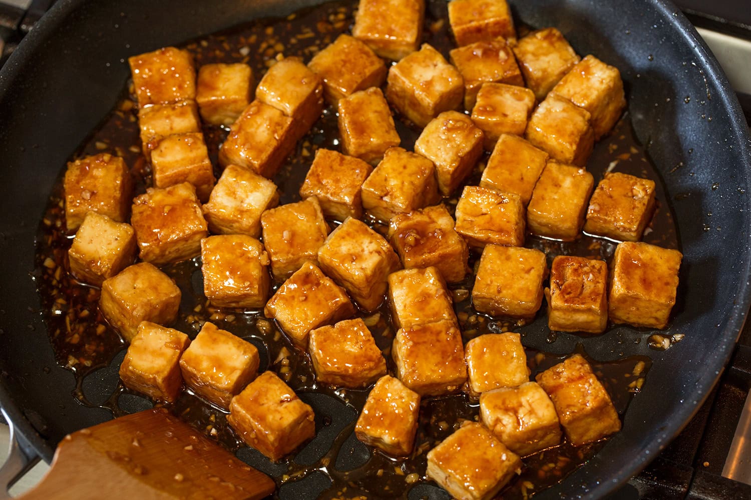 Teriyaki tofu in teriyaki sauce in skillet.