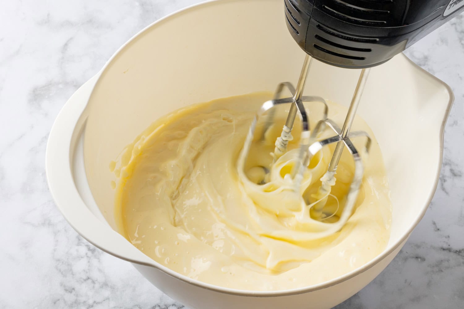 Lemon Icebox Pie Pie mixture being blended with electric hand mixer.