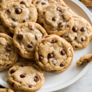 Plate full of browned butter chocolate chip cookies overlapping.
