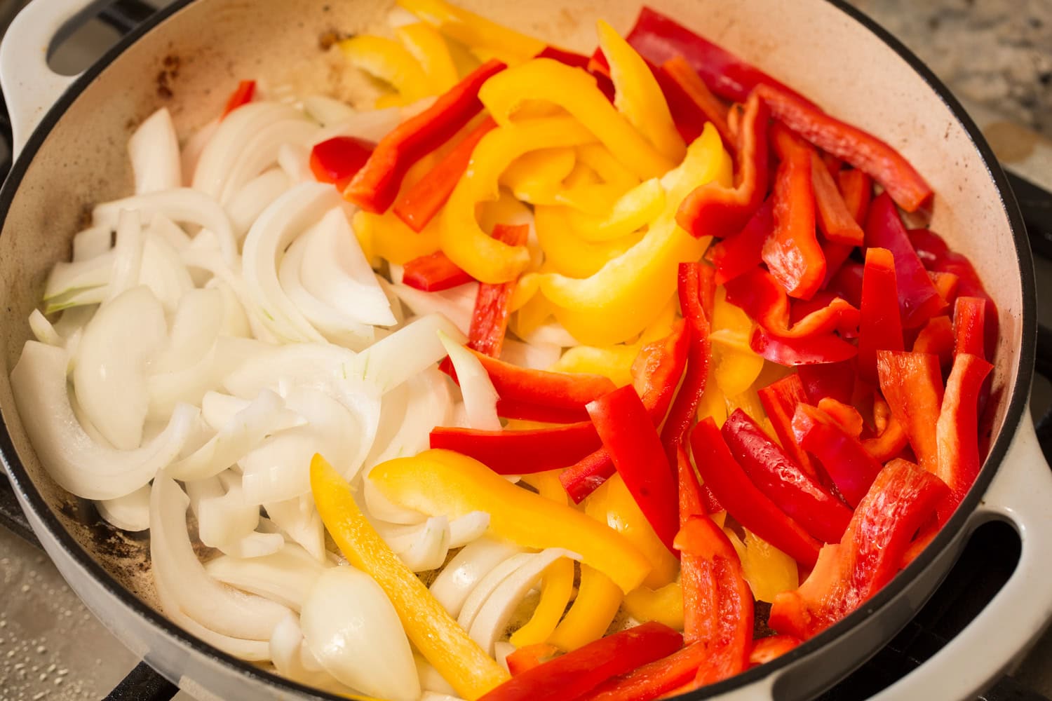 Italian Sausage Peppers and Onions Adding raw peppers and onions to pan.