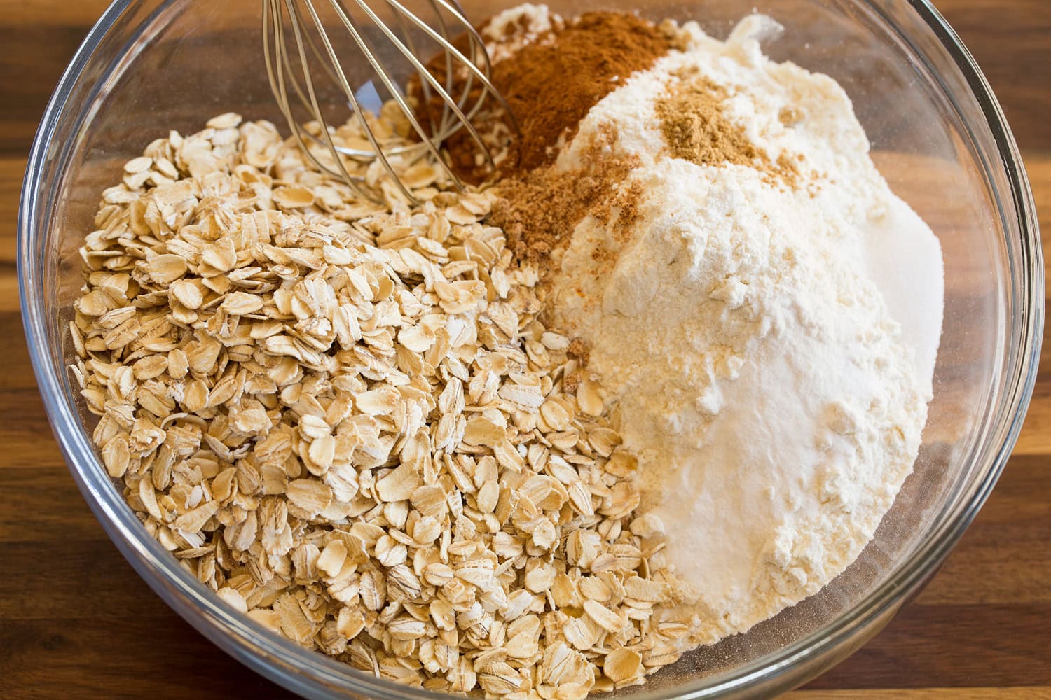 Oatmeal Cream Pies Mixing dry ingredients for oatmeal cookie dough in glass bowl.
