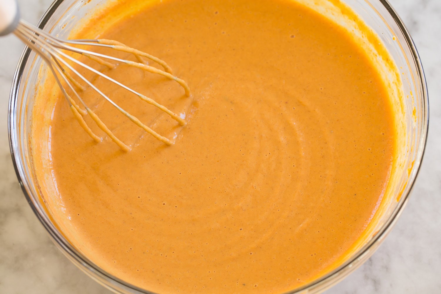 Mini Pumpkin Pies Pumpkin pie filling whisked in a glass mixing bowl.