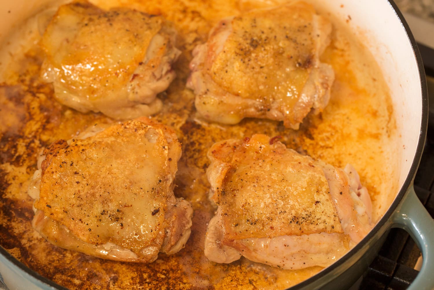 Coq au Vin Chicken thighs browned in a pot.