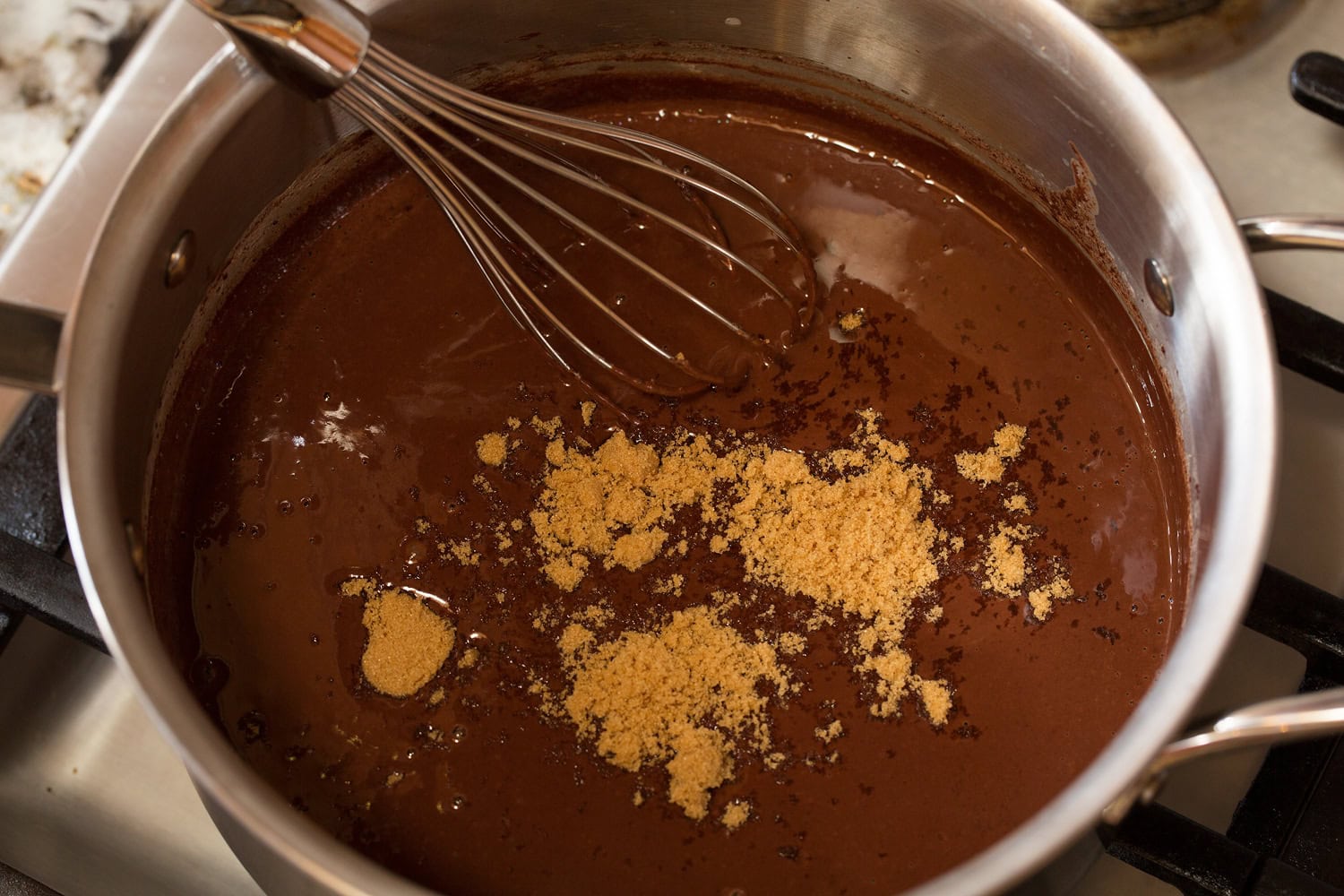 French Hot Chocolate Brown sugar added to melted chocolate and milk mixture in saucepan.