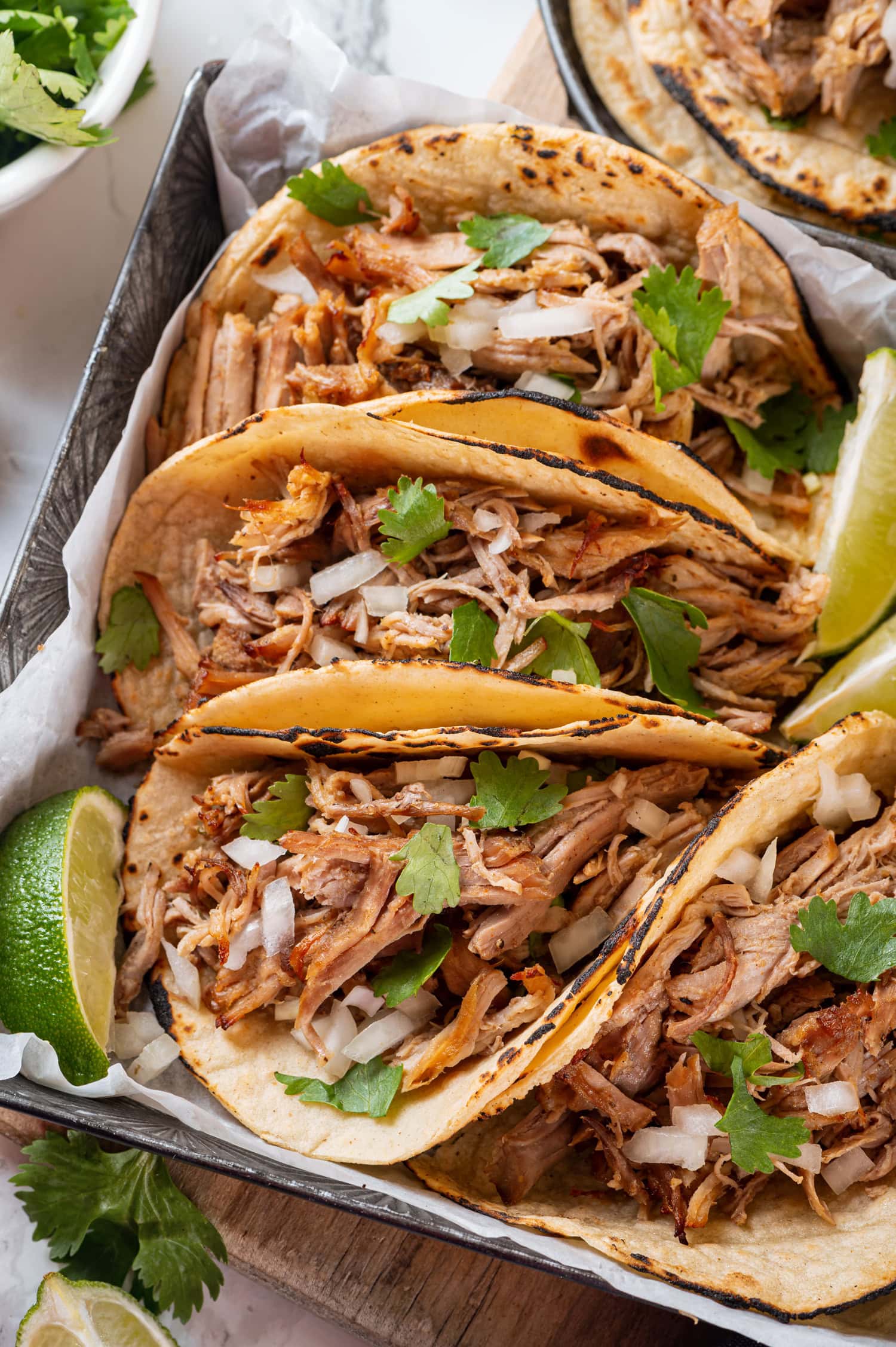 Close up photos of carnitas in tortillas.