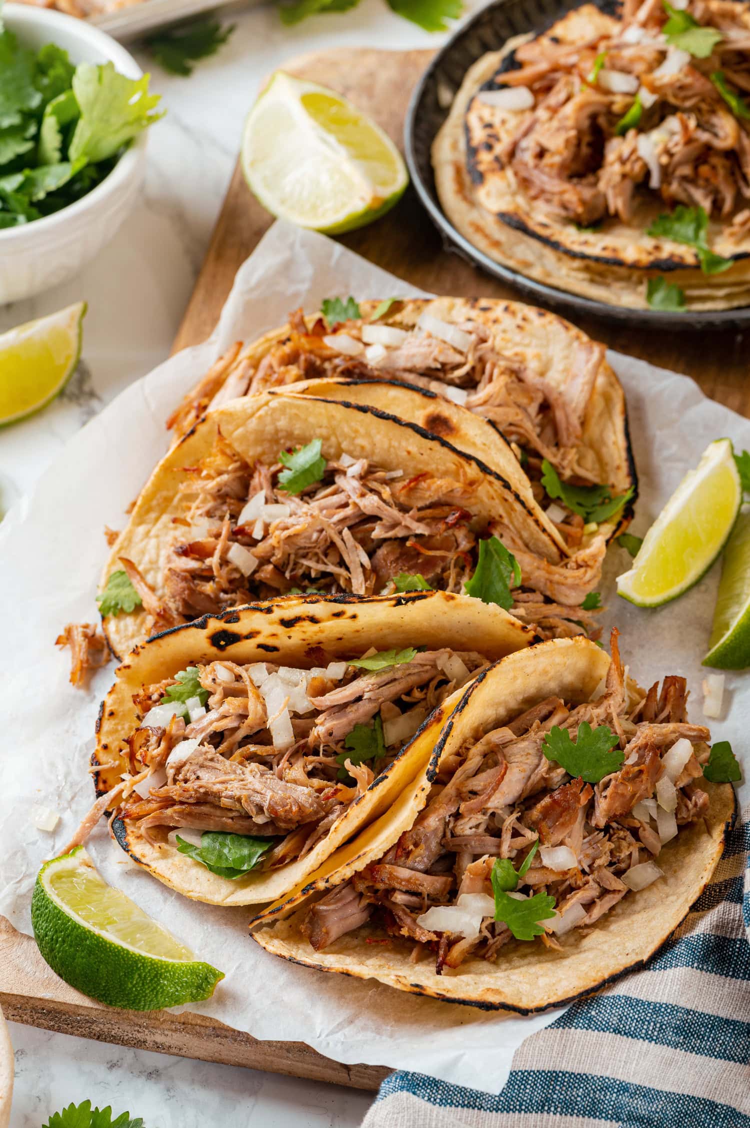 Pork carnitas shown in tortillas as tacos.