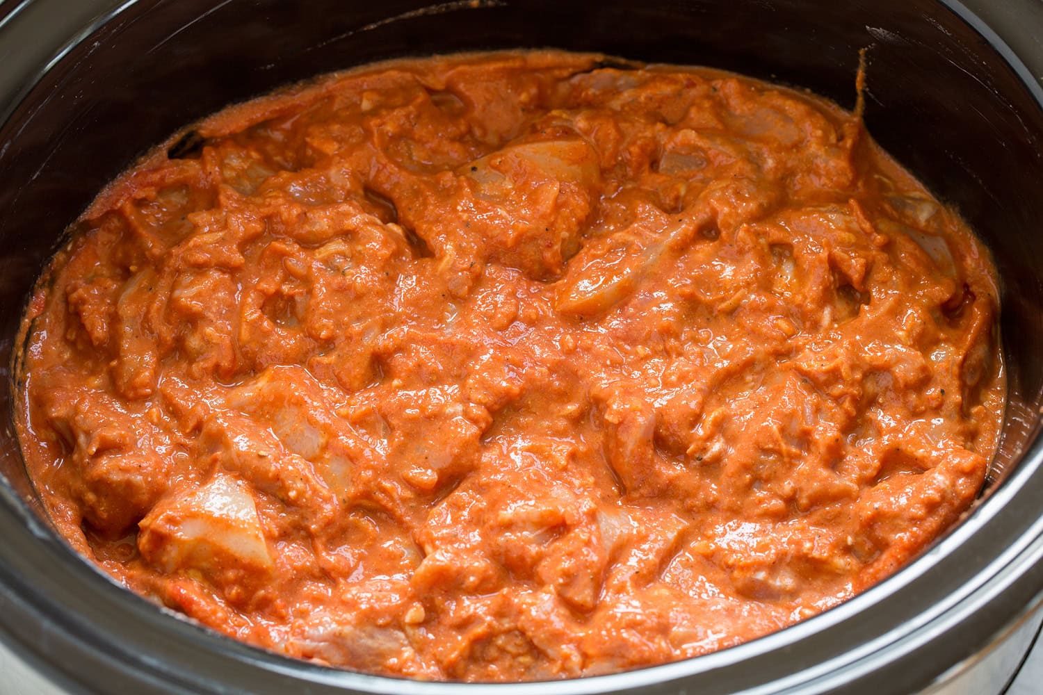 Slow Cooker Chicken Tikka Masala Chicken mixture tossed in slow cooker, shown before cooking.