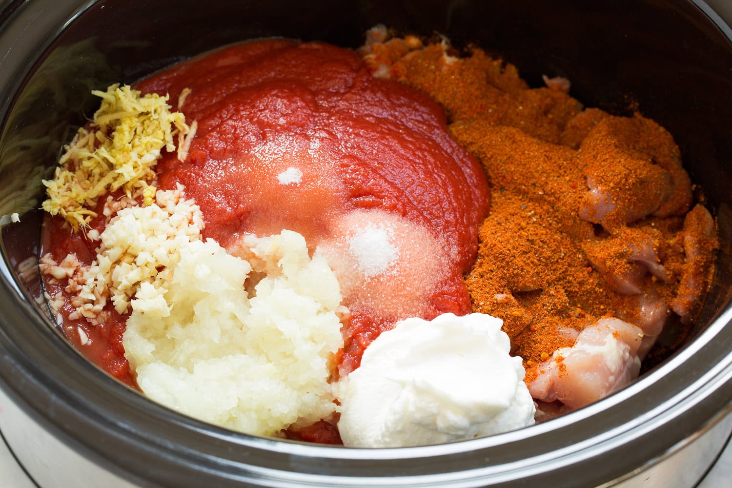 Slow Cooker Chicken Tikka Masala Tomato puree, onion, garlic, ginger, and yogurt added to chicken mixture.