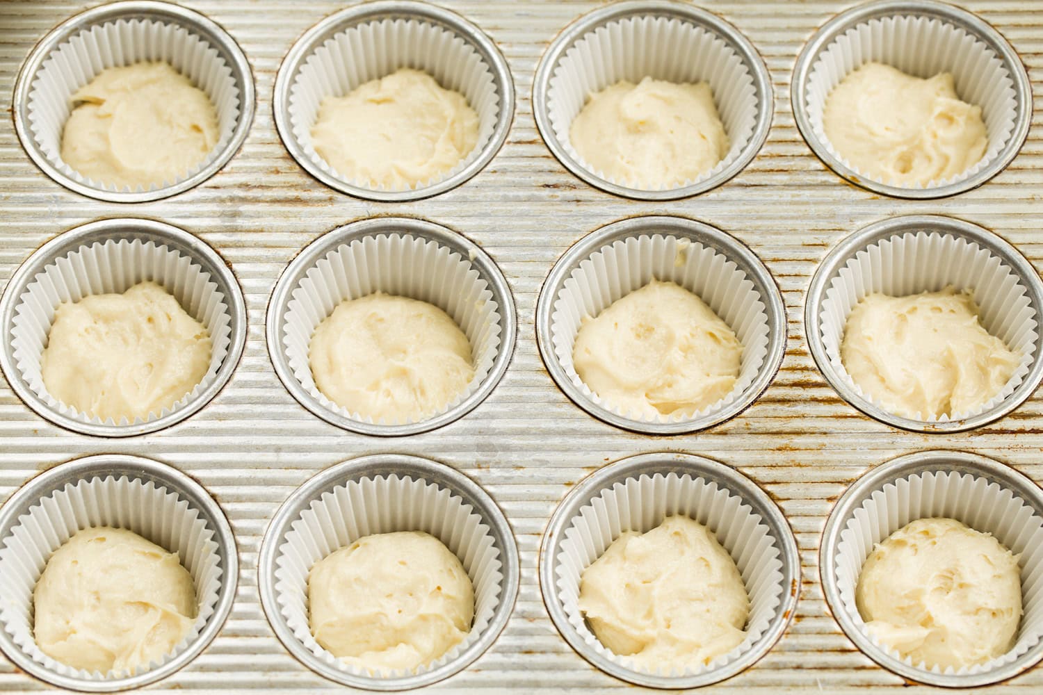 Tiramisu Cupcakes Vanilla portion of cupcake batter added to muffin pan.