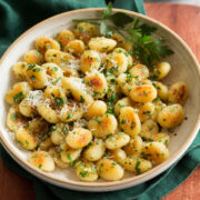 Pan fried gnocchi shown with parmesan and parsley garnish.