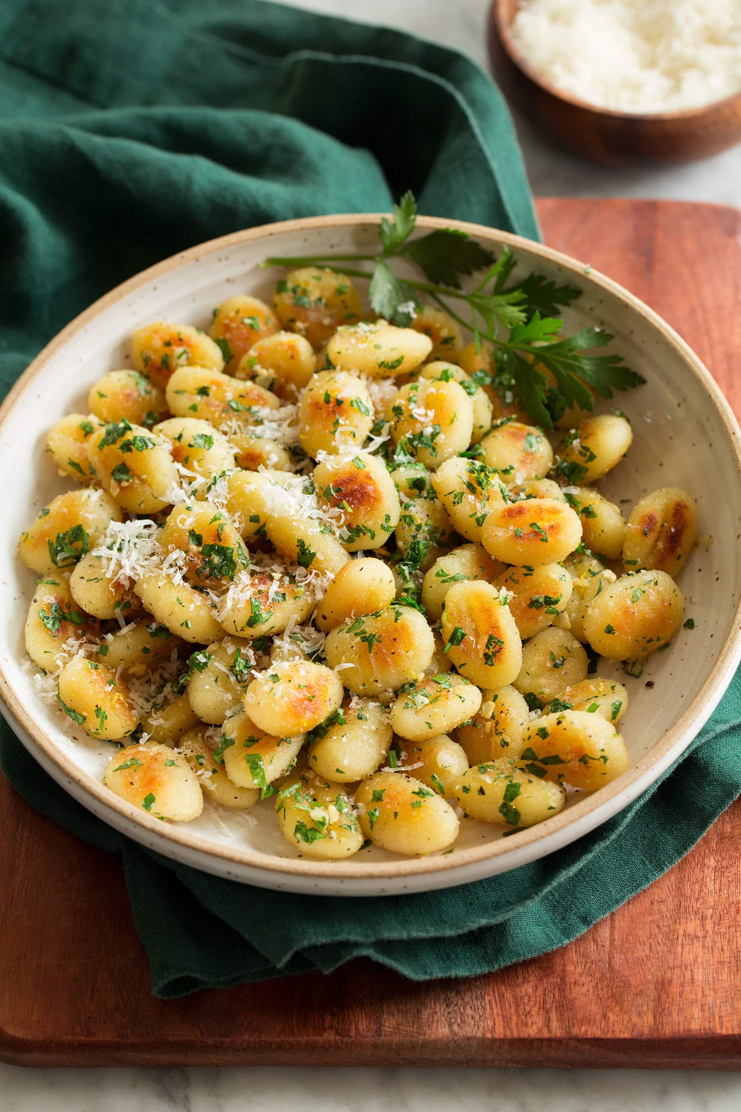 Pan fried gnocchi shown with parmesan and parsley garnish.