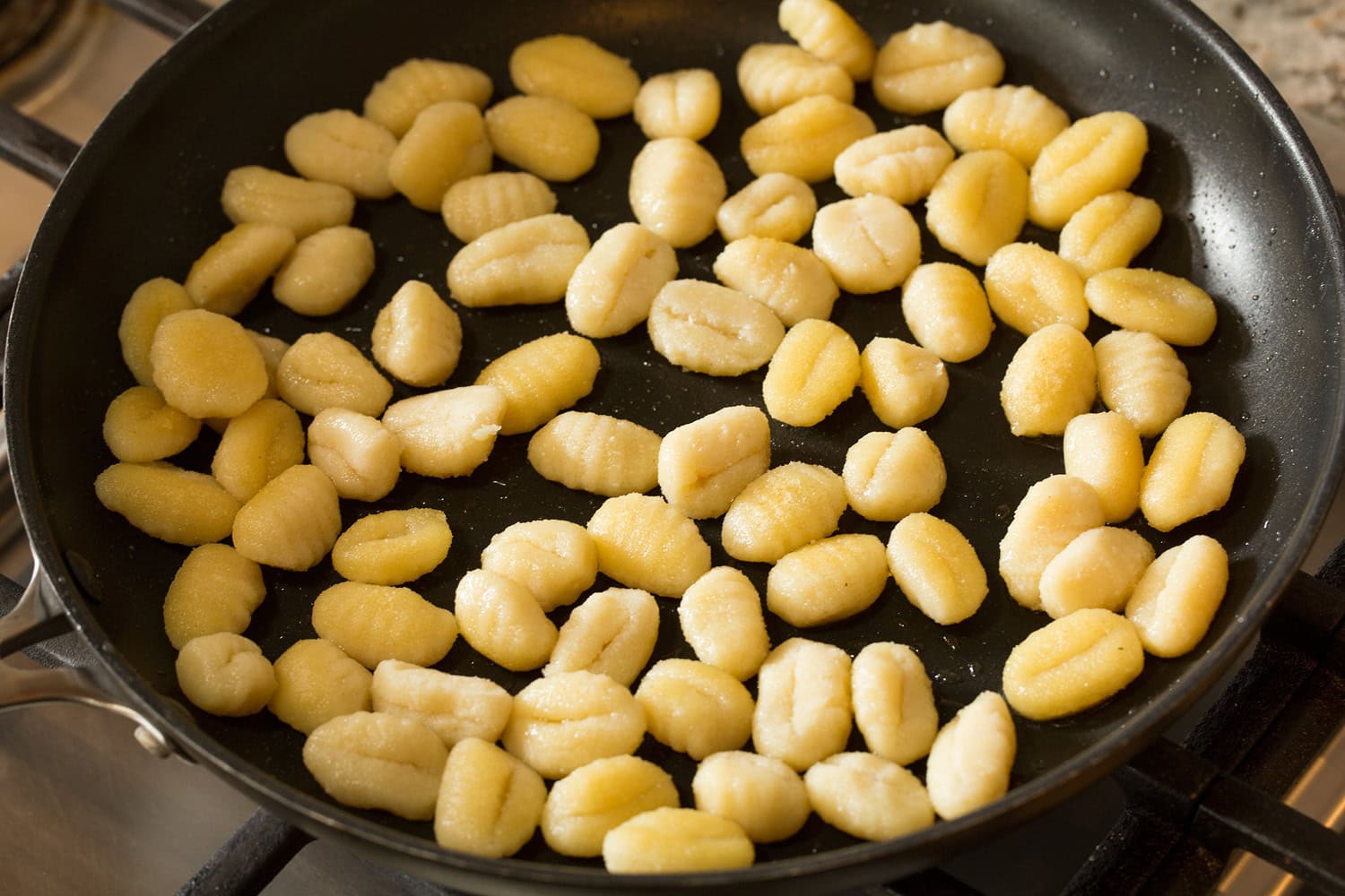 Pan Fried Gnocchi Gnocchi being sauteed in a skillet.