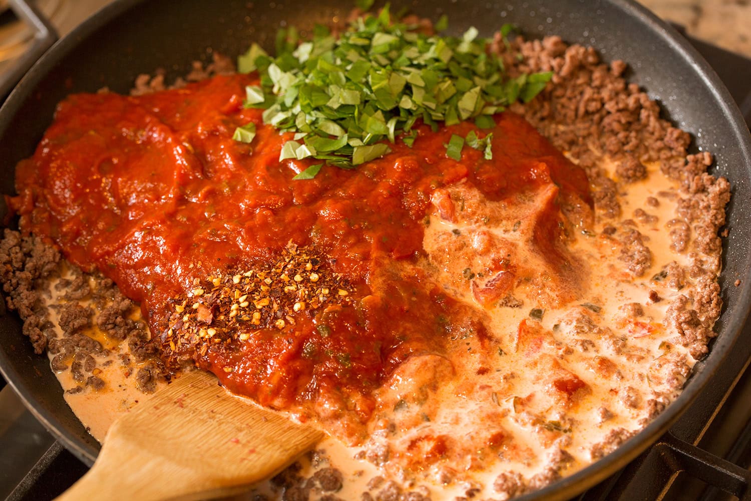 Beef marinara sauce and with half and half and basil added in a skillet.