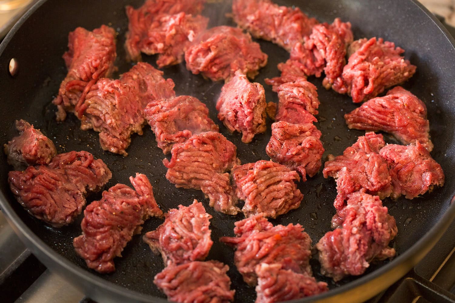 Burger Bowls Raw ground beef in skillet in chunks.