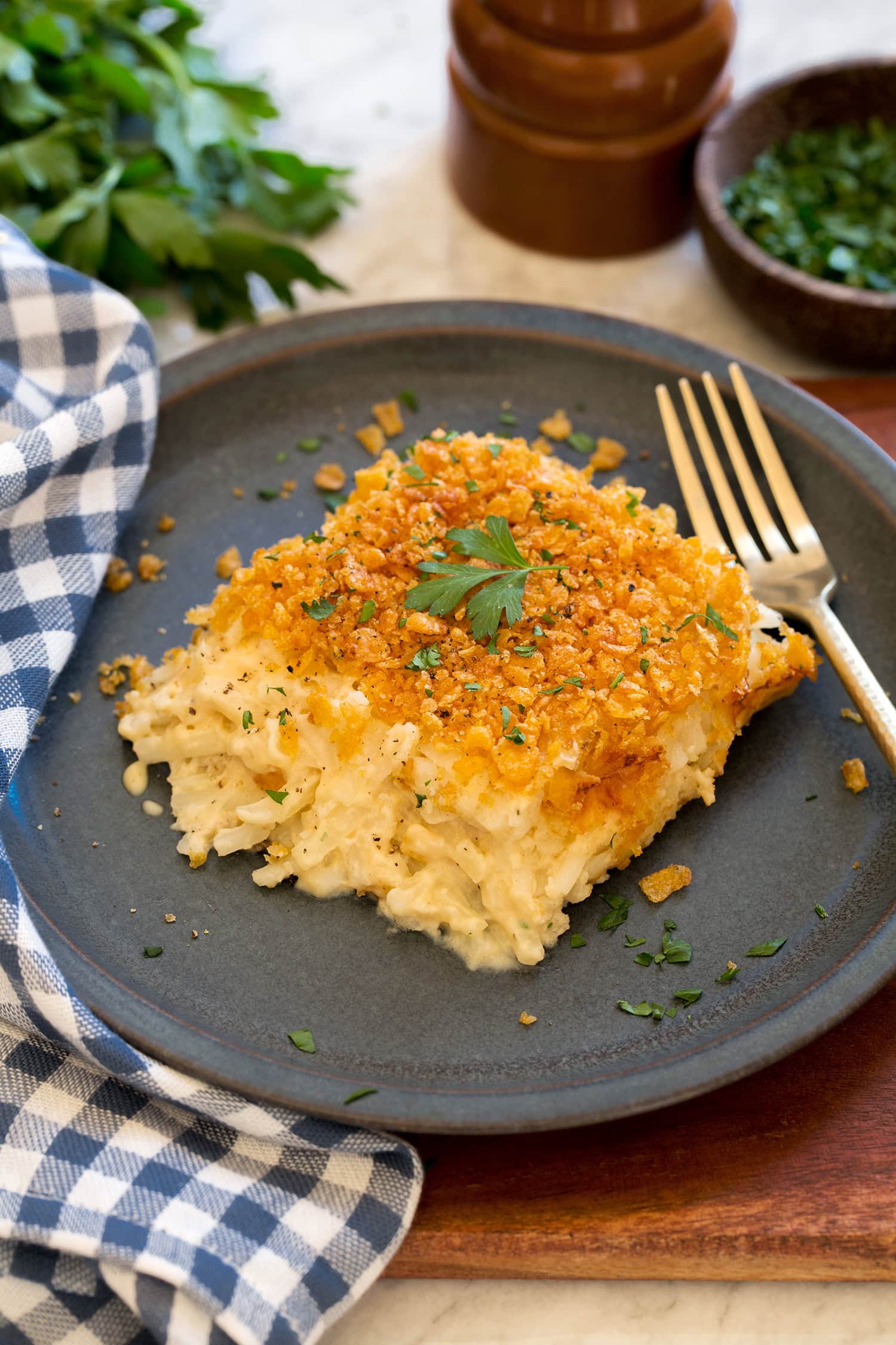 Single serving of funeral potatoes on a blue plate.