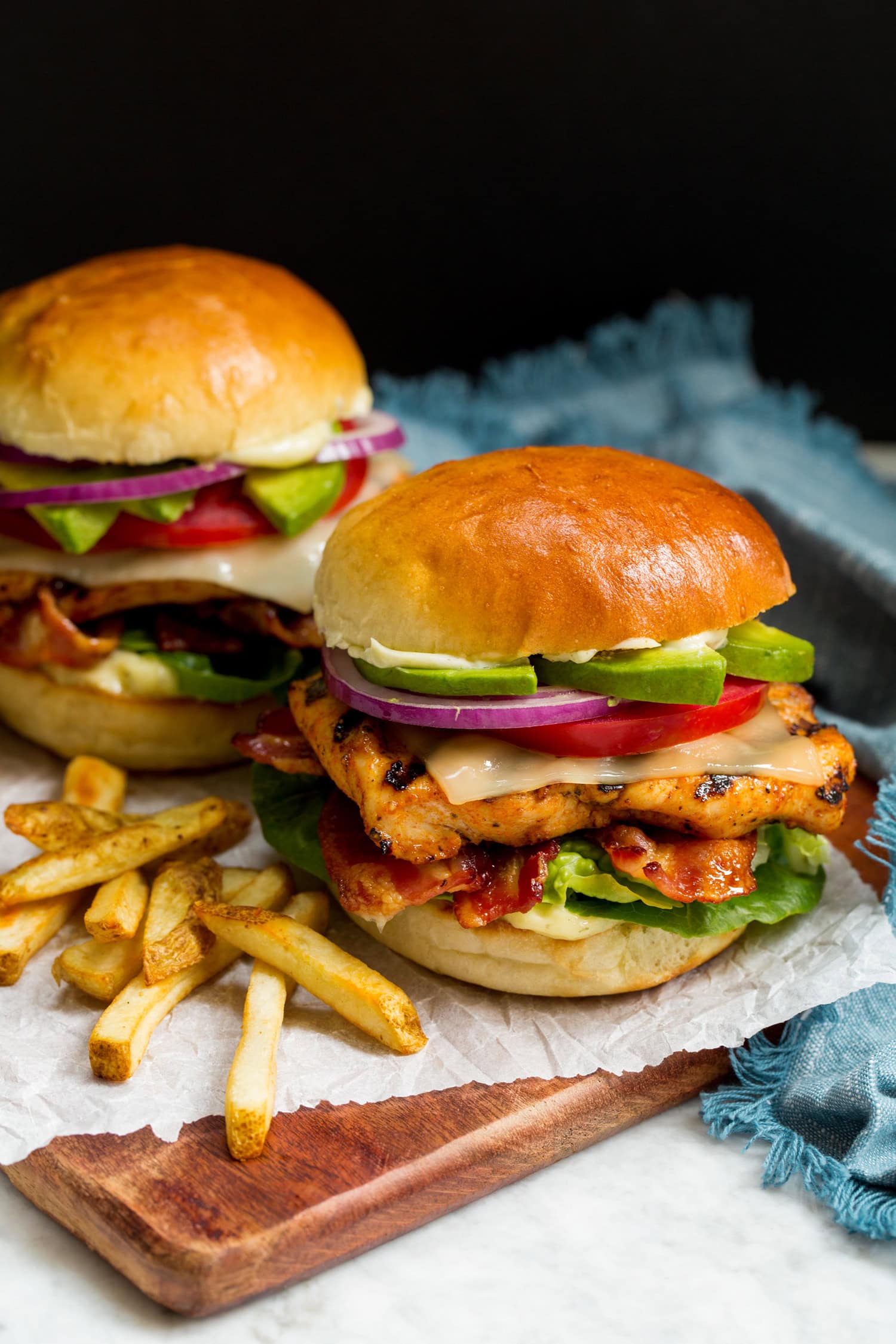 Grilled Chicken Sandwiches Grilled Chicken Sandwich layered with grilled chicken breast, lettuce, bacon, cheese, tomato, avocado, ranch mayo and buns.