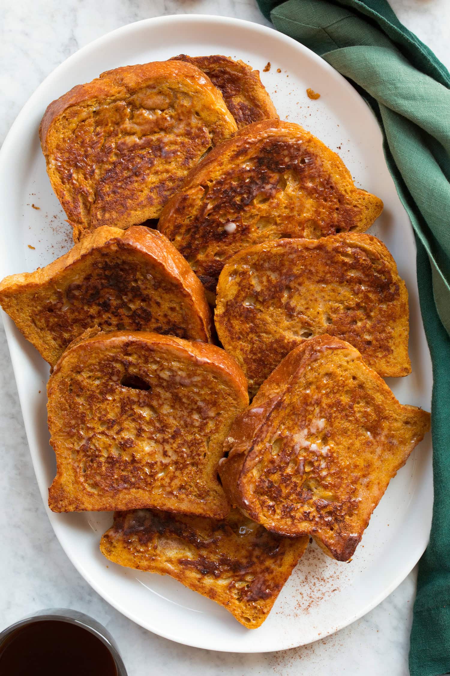 Plain pumpkin french toast without toppings shown overhead on an oval serving platter.