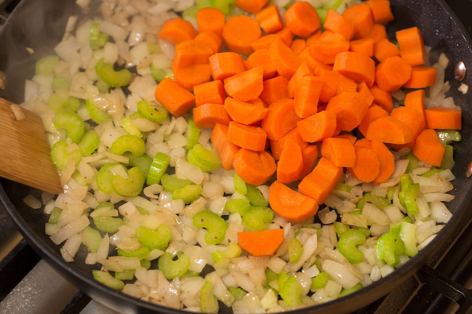 Slow Cooker Ground Beef Stew Carrots, celery and onions in a skillet sautéing.