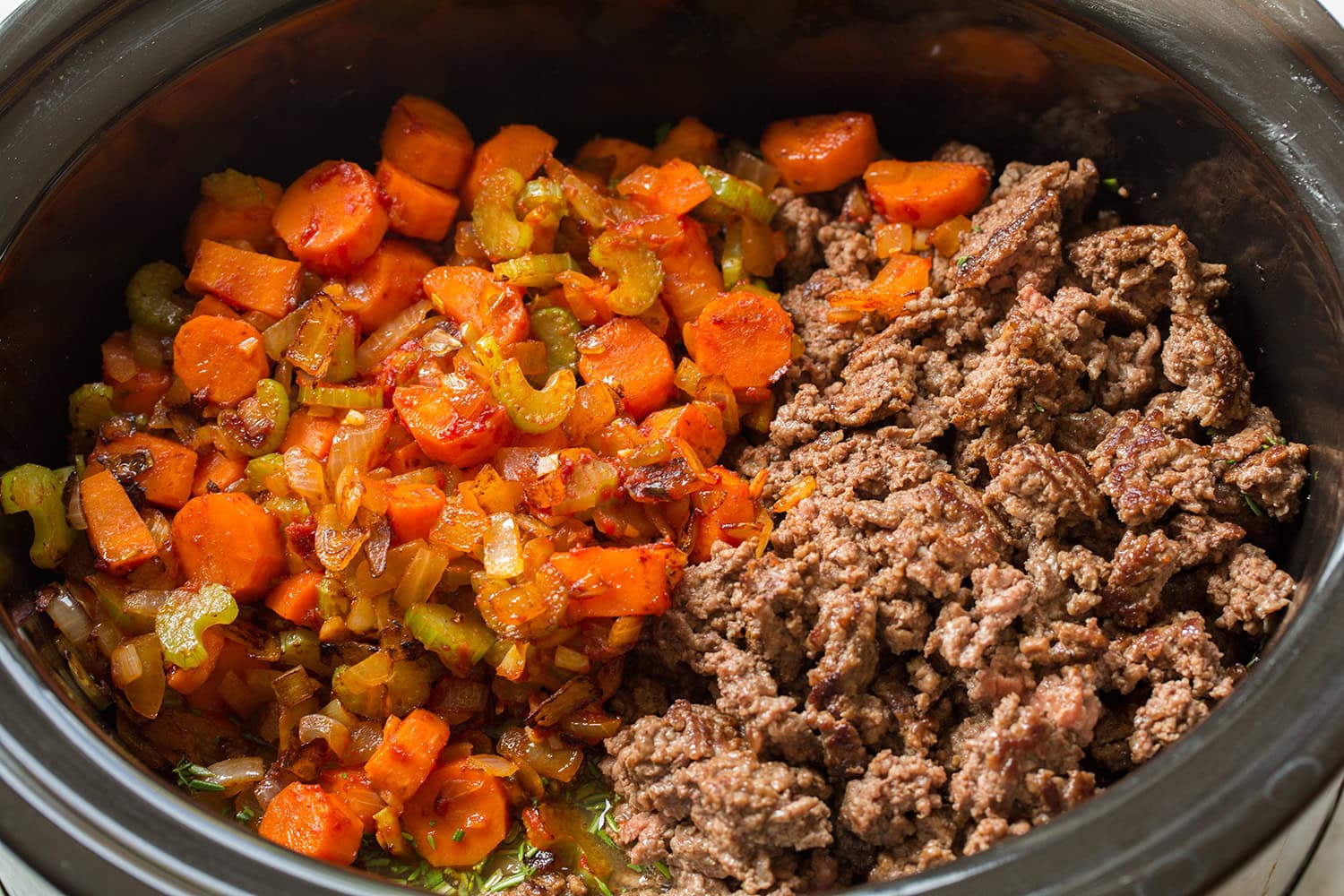 Slow Cooker Ground Beef Stew Cooked vegetables and browned beef added to slow cooker.