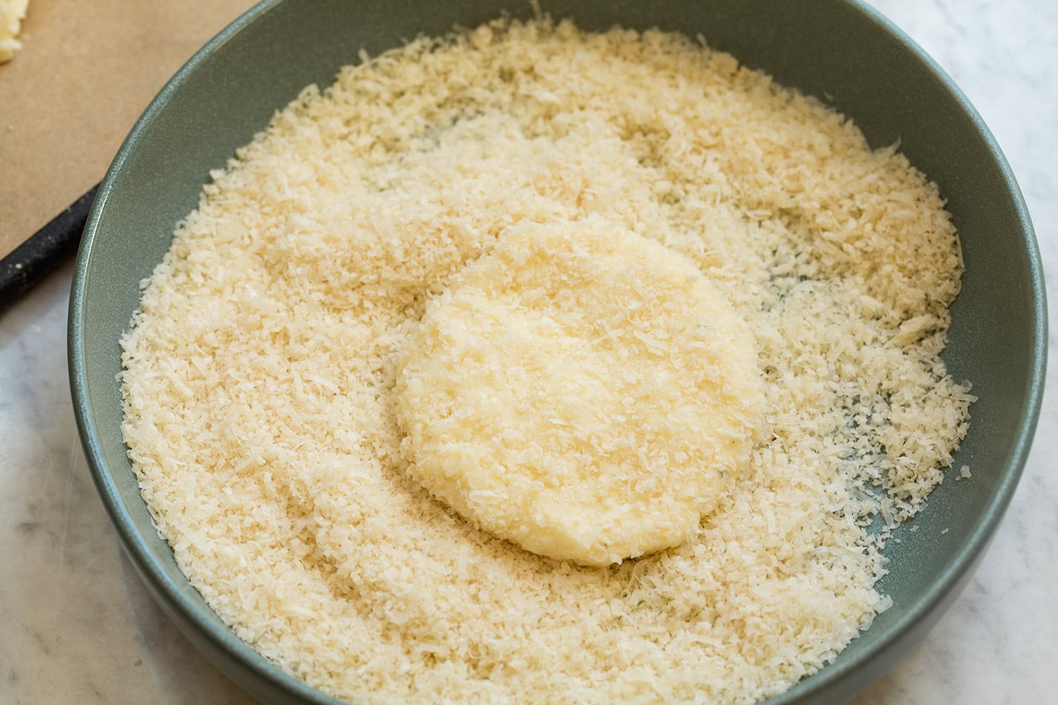 Mashed Potato Cakes Potato cake pattie being coated in panko bread crumbs and parmesan.