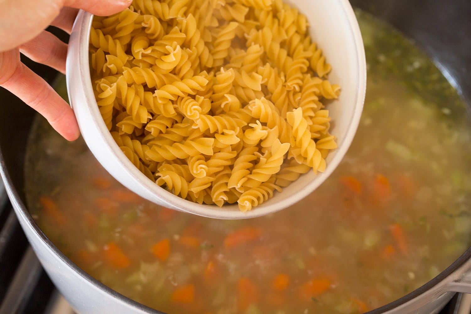 Turkey Soup Noodles being added to stock in pot.