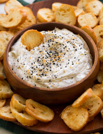 Everything bagel dip shown with homemade bagel chips on a platter.