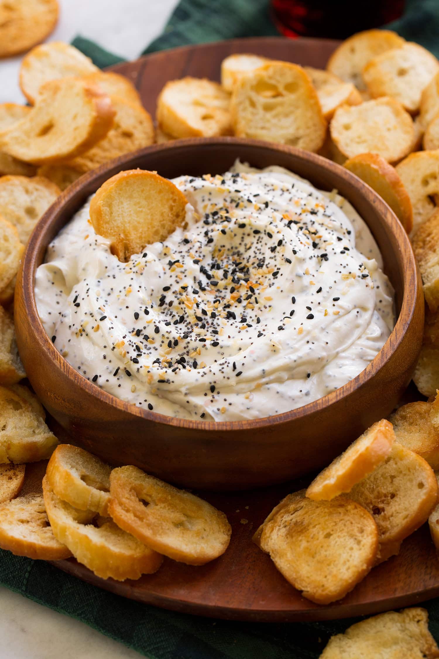 Everything bagel dip shown with homemade bagel chips on a platter.