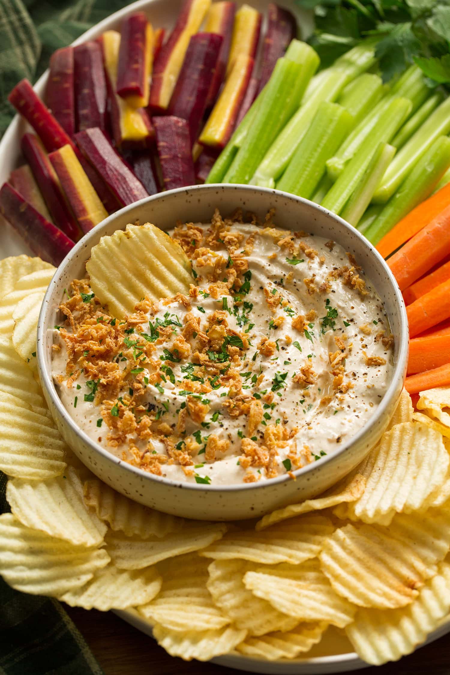 Platter with veggies, potato chips and french onion dip.