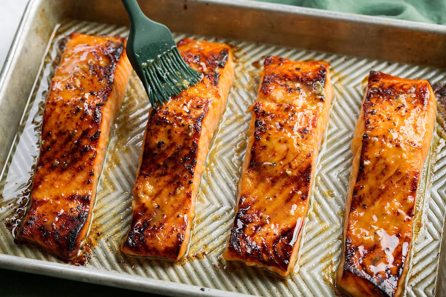 Salmon with miso shown after broiling with more marinade being brushed over tops.
