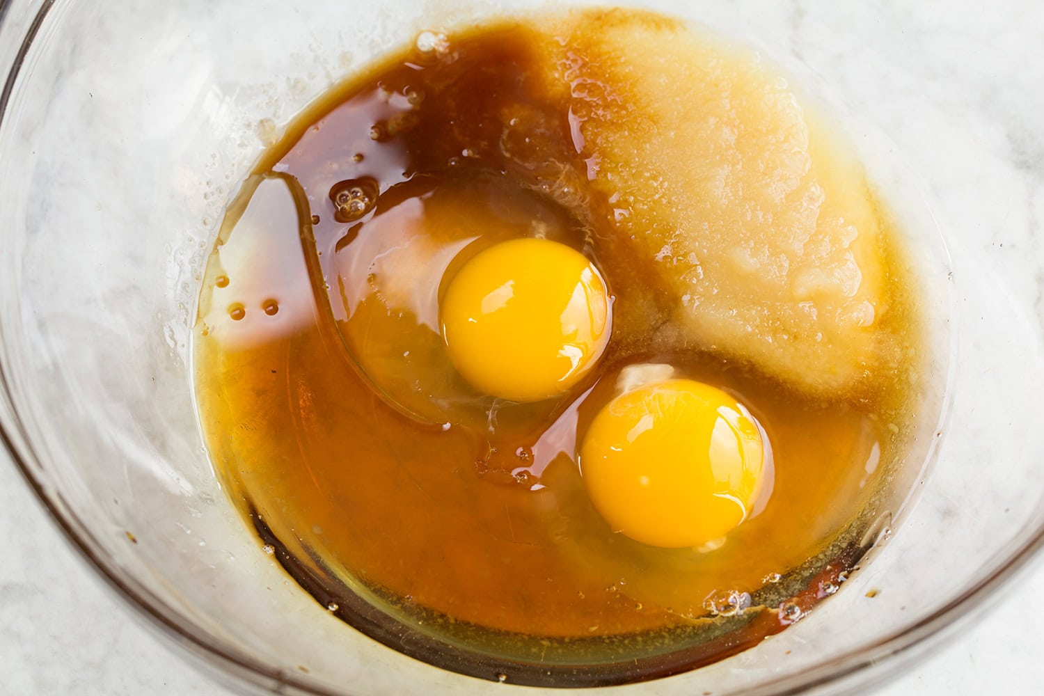 Egg, oil and applesauce mixture in glass dish.