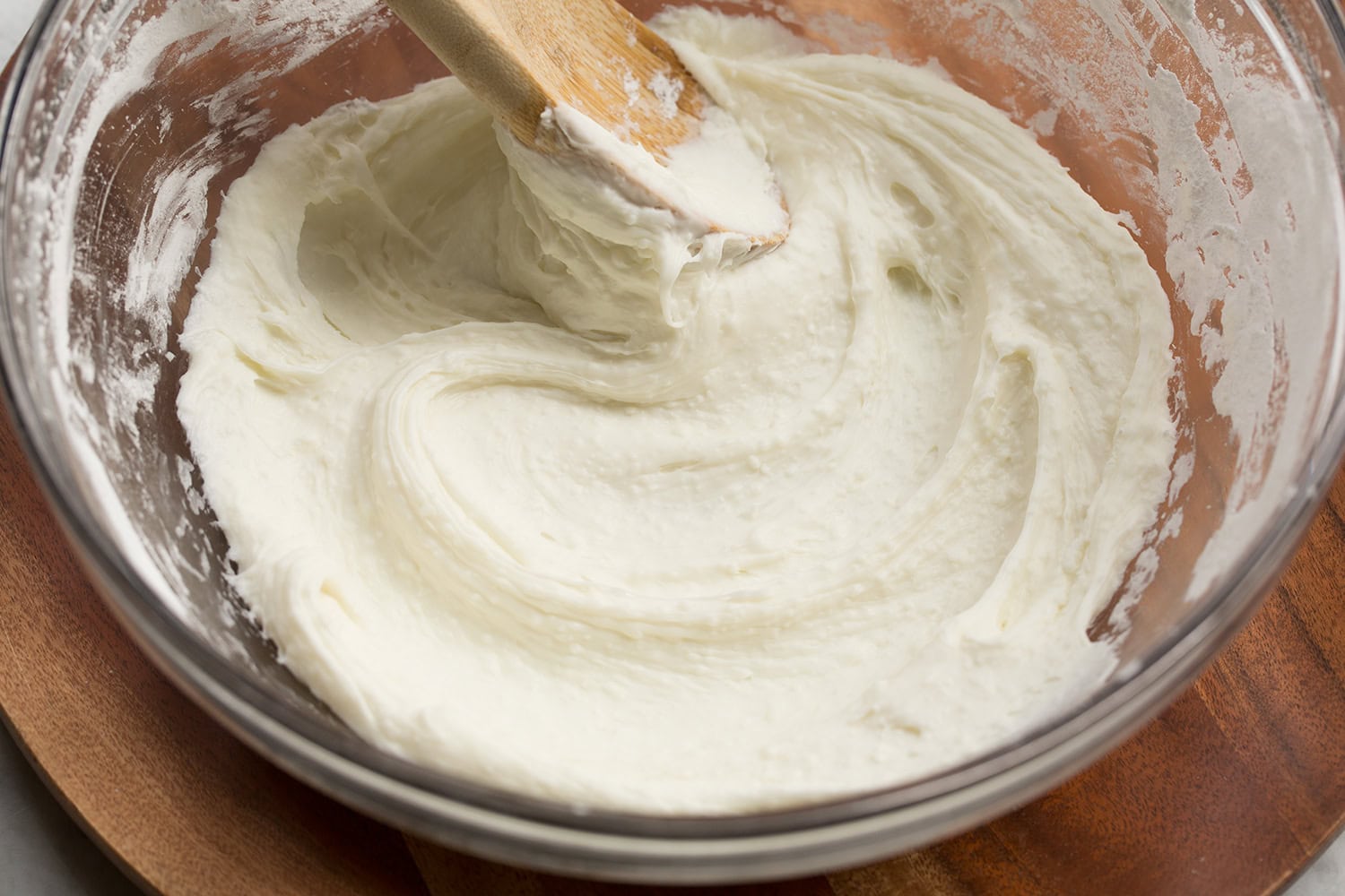 Brazilian Cheese Bread (Pão de Queijo) Blended milk and tapioca flour mixture with a wooden spoon to the side.