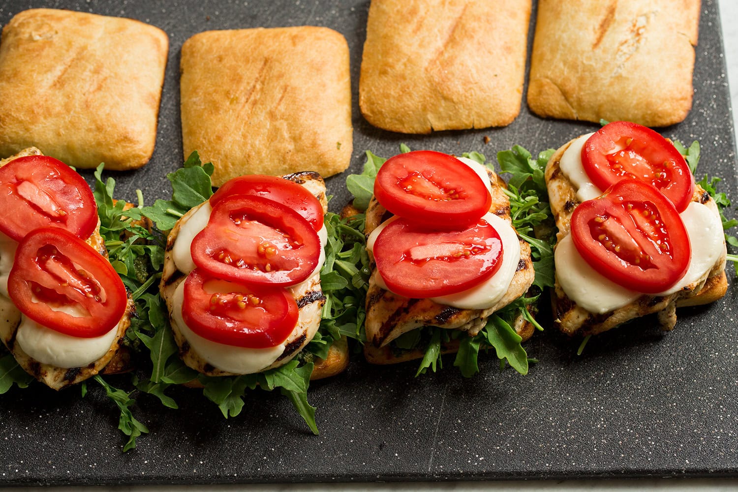 Tomatoes layered over sandwiches.