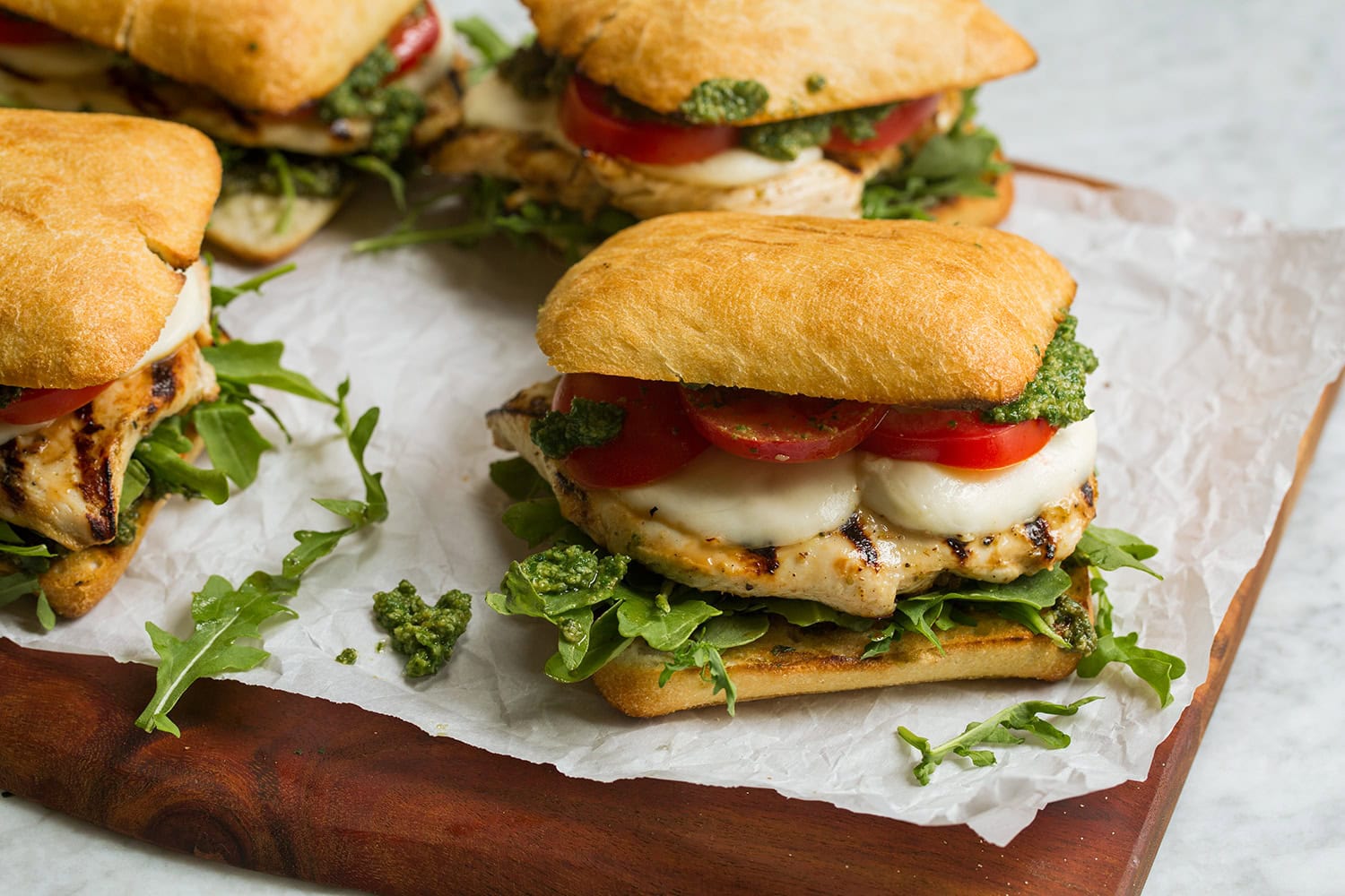 Four completed chicken breast pesto sandwiches.