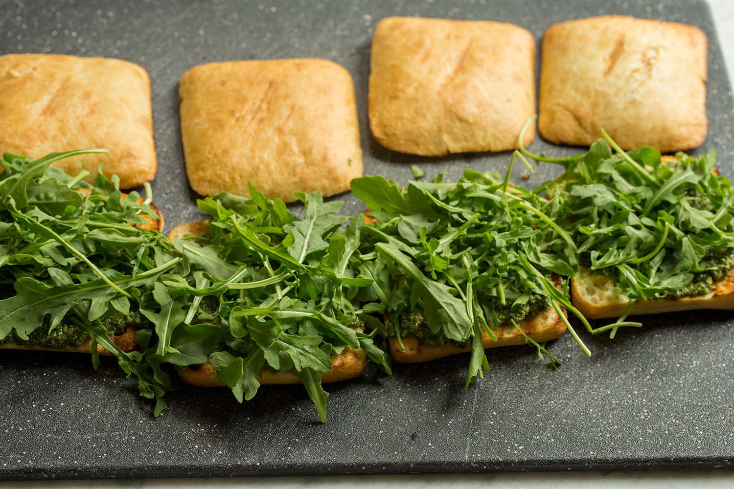 Arugula layered onto sandwiches.