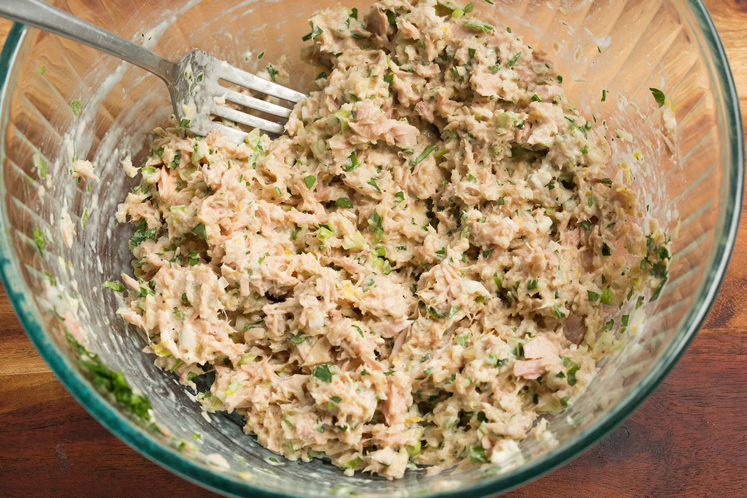 Tuna patty mixture shown in glass mixing bowl after mixing.