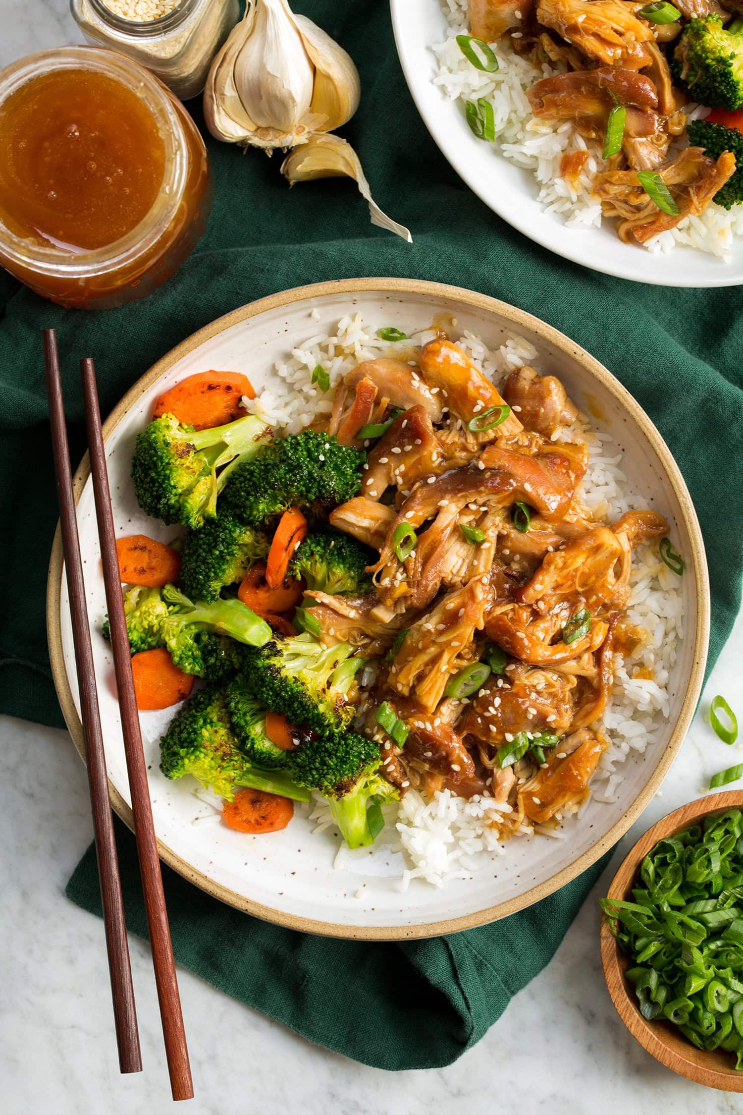 Overhead image of crockpot honey garlic chicken with serving suggestions.